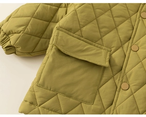 Detail view of mustard quilted jacket featuring large flap pockets and snap buttons