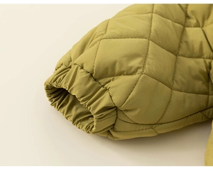 Detail of diamond quilted mustard yellow jacket sleeve with elastic cuffs and windproof fabric