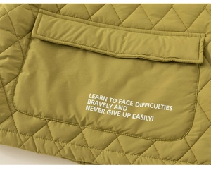 Close-up of olive green quilted jacket showing fabric texture and printed text detail