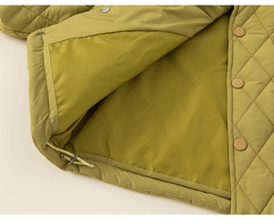 Detailed view of olive green quilted jacket with diamond patterns and hem drawstring