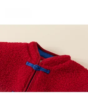 Détail d'une veste en polaire rouge avec col mandarin et boutons chinois faits main en bleu