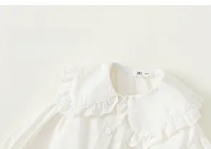 Detailed close-up of white cotton girl's shirt featuring a lace Peter Pan collar