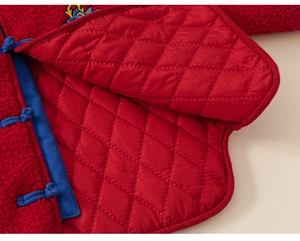 Détail d'un costume Tang rouge pour enfant montrant la doublure matelassée et les boutons