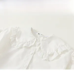 Close-up of girls' white shirt featuring a delicate Peter Pan collar with lace edges