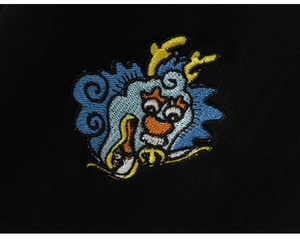 Détail de la broderie de dragon colorée sur tissu d'hiver noir pour tenue d'enfant