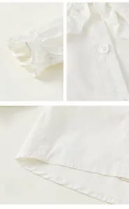 Detailed macro view of lace cuffs and button closure on white cotton girls' shirt