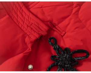 Detail von traditionellen chinesischen Knoten und Knöpfen an einer roten gesteppten Jacke
