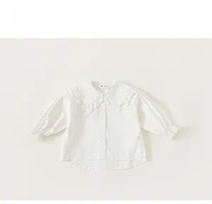 Detail view of white toddler girl shirt with large ruffled collar and elastic cuffs