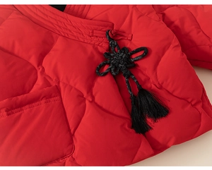 Detail der roten gesteppten Winterjacke mit traditionellem chinesischem Verschluss und Quaste
