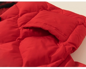 Detail der roten gesteppten Kinder-Daunenjacke mit Knopftasche und dekorativer Quaste
