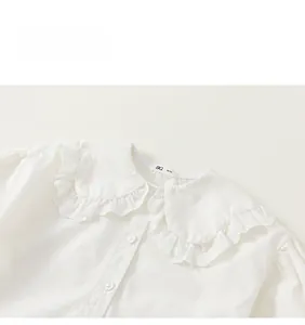 Detailed macro view of girls white cotton shirt with lace embroidered ruffle collar