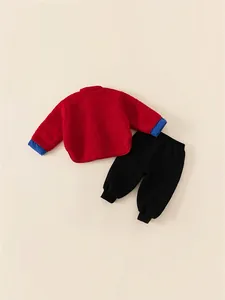Ensemble d'hiver festif pour enfants avec veste polaire rouge et pantalon noir chaud