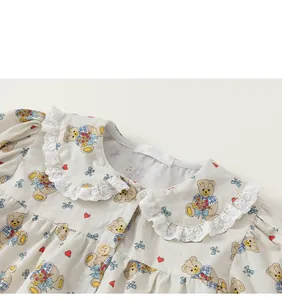 Detail der Baby-Blumenbluse mit Teddybär-Print, Peter-Pan-Spitzenkragen und beige Knöpfen