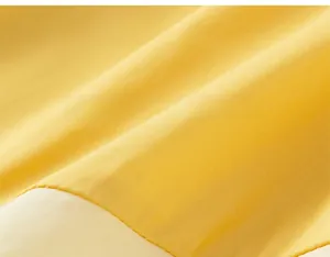 Detailed view of yellow and cream patchwork cotton fabric texture on A-line dress