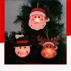 Close-up of LED glowing wooden ornaments with Santa, snowman and deer on Christmas tree