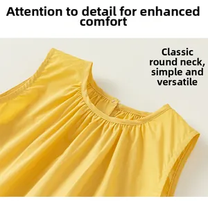 Detailed view of the classic crew neck and pleat texture on this yellow sleeveless dress