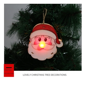 Detail of wooden Santa Claus ornament with glowing LED nose on Christmas tree