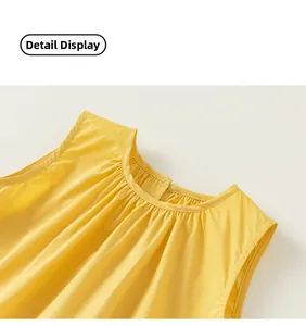 Detail of girls yellow cotton dress featuring round pleated neckline and back button closure