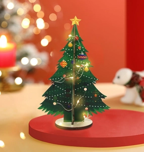 Detail view of a DIY glowing wooden Christmas tree with warm LED lights on a table