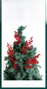 Detail of red artificial berry branches decorating a green Christmas tree branch