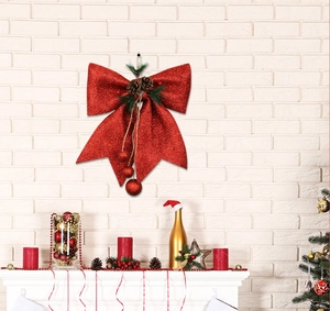 Detailed view of a red glitter Christmas bow with pine cones and hanging ball ornaments