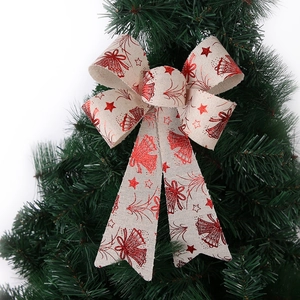 Christmas bow ornament with red glitter star patterns on rustic linen for tree decoration