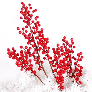 Close-up of vibrant red Christmas berry stems with glossy finish on snowy base