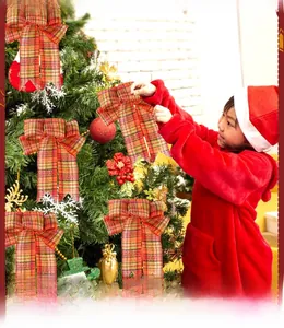 Detail of red and yellow plaid Christmas bow with long ribbons for tree decoration