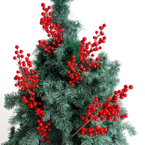Artificial red Christmas berry stem branches with green pine needles on white background