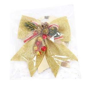Glittery gold Christmas tree bow with pine cones and red berries in protective packaging