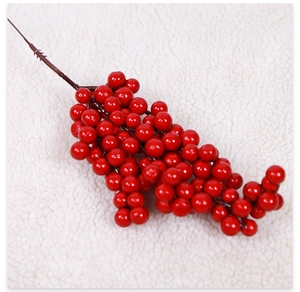 Close-up of vibrant red artificial berry stems on a soft white faux fur background