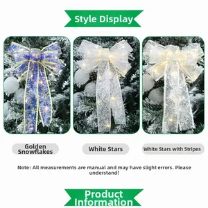 Detail of LED glowing Christmas bows with golden snowflakes and stars on snowy tree
