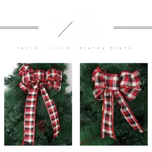 Close-up of red and black plaid Christmas bow ornaments hanging on pine tree branches