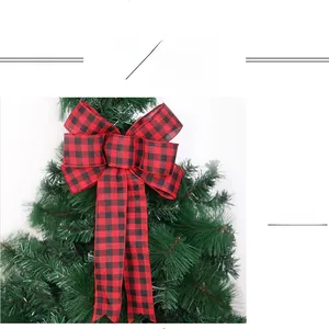 Close-up of a red and black buffalo plaid Christmas bow tied on green pine branches