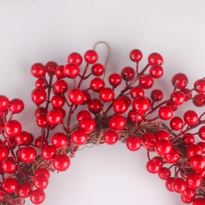 Détail de baies rouges artificielles sur une base de couronne en vigne séchée naturelle
