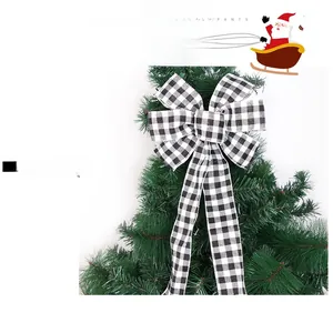 Detail of a large black and white buffalo plaid bow hanging on a green Christmas tree