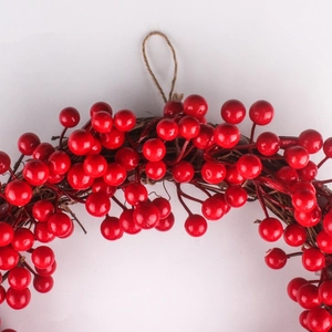 Gros plan d'une couronne de baies rouges de Noël avec brindilles et corde de chanvre brune