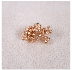 Close-up of rose gold berry clusters on white fleece, detailed Christmas tree decorations