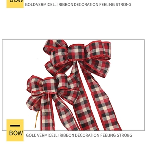 Detail of red and black plaid Christmas bow with gold wired edges and long ribbons