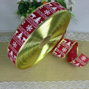 Detail of red faux linen Christmas ribbon with white reindeer and snowflake patterns
