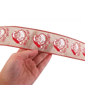Detail view of burlap Christmas ribbon with Santa Claus patterns and Ho Ho Ho slogan