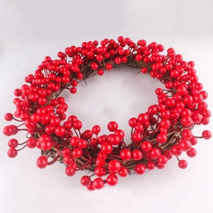 Couronne de Noël avec baies rouges artificielles sur une base de vigne brune rustique