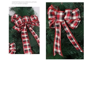 Detailed view of red and black buffalo plaid Christmas bow ornament on green pine branches