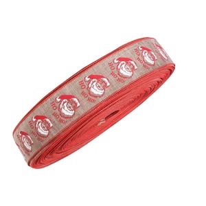 Detail of Christmas ribbon roll with Santa Claus pattern and Ho Ho Ho print on burlap texture