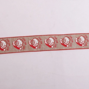 Close-up of burlap Christmas ribbon with HO HO HO Santa Claus print and red stitched edges