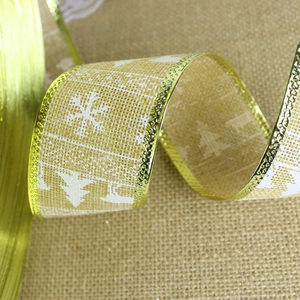Close-up of 2m burlap Christmas ribbon with white snowflake and tree prints and gold edges