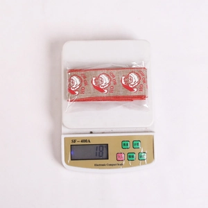 Detailed view of Christmas HoHoHo ribbon on scale showing 18g weight for gift wrapping