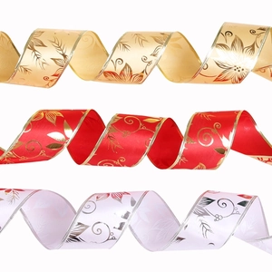 Detail of Christmas ribbons with floral vine prints and gold wire edges in red and white