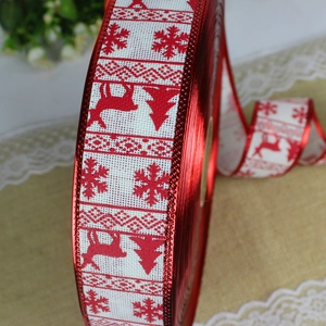 Detail of red Christmas faux linen ribbon with white snowflake and reindeer prints