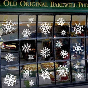 Detailed view of white snowflake window clings with various geometric patterns for Christmas